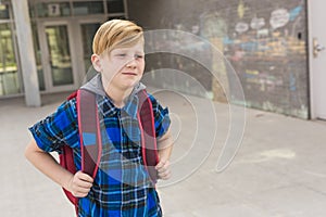 Pre teen boy outside at school lonely