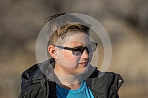 Pre-teen boy outside wearing sunglasses