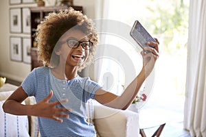 Pre-teen girl filming herself singing using a social media app on her smartphone, close up