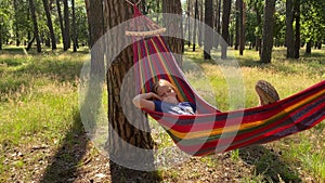 Pre-teen girl relaxing in hammock amid nature beauty on a sunny day