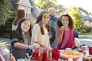 Pre-teen girls smiling to camera at a block party, close up photo