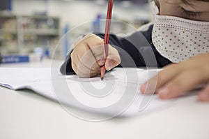Pre-writter child boy doing calligraphy exercises with booklets