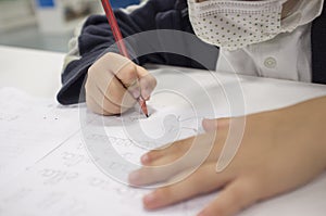Pre-writter child boy doing calligraphy exercises with booklets photo