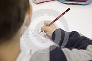 Pre-writter child boy doing calligraphy exercises with booklets