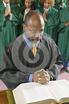 Preacher by altar in church Bowing Head in Prayer