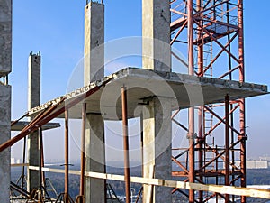 Precast concrete elements of the building at height. The frame of columns and plates is fastened with steel supports