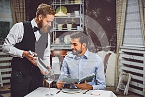 Precautionary waiter offering wine to visitor