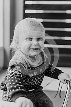 Precious Adorable Cute Little Blonde Baby Toddler Boy Kid Playing Outside on Wooden Toy Bicycle Scooter Mobile Smiling at the Came