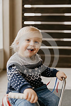 Precious Adorable Cute Little Blonde Baby Toddler Boy Kid Playing Outside on Wooden Toy Bicycle Scooter Mobile Smiling at the Came