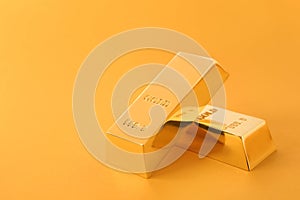 Precious shiny gold bars on color background.