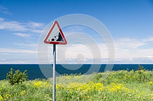 Precipice edge warning sign. Danger sea cliff hidden by grass