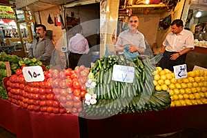 Precisely arranged piles of tomatoes, cucumbers lemons and peppers in front of grocers at bazaar market, Iraq, Middle East