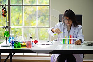 Precision and focus the female scientist carefully poured of one chemical flask.