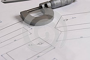 Precision micrometer placed on engineering technical drawings