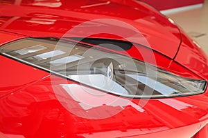 Predatory car headlight and hood of powerful sports car with matte paint.