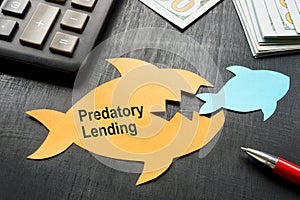 Predatory lending concept. Two paper fish on the office table. photo