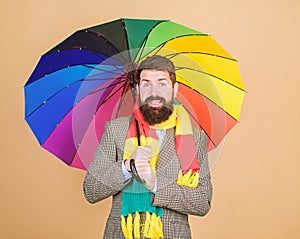 Predict future weather trends. Man bearded guy hold colorful umbrella. It seems to be raining. Rainy days can be tough