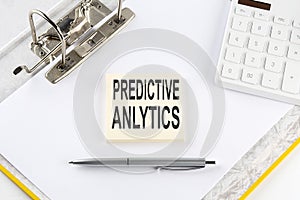 PREDICTIVE ANALYTICS - business concept, message on the sticker on folder background with calculator