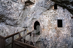 Predjama Castle in Slovenia. Interior of a castle hidden in a cave. Entrance to the fortification with a wooden bridge.