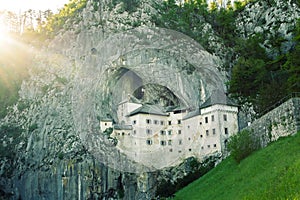 Predjama castle in the rock wall with lensflare on the left, Slovenia