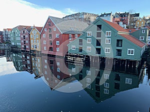 Timber buildings alongside calm water in city of Trondheim, Norway photo