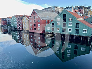 Timber buildings alongside calm water in city of Trondheim, Norway photo