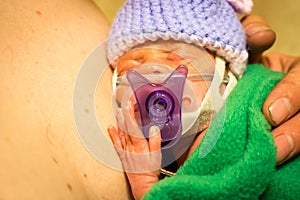 Preemie newborn girl skin to skin with dad