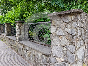 prefab metal fence on concrete foundation pile of stones loose stone construction of houses and yards construction works