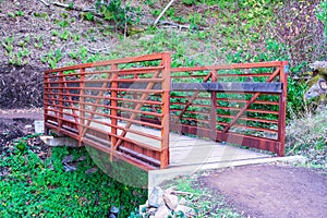 Prefabricated small steel bridge on hiking trail over dry creek in park