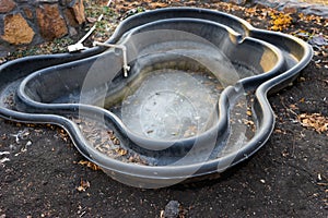 Preformed plastic pond with frozen water.