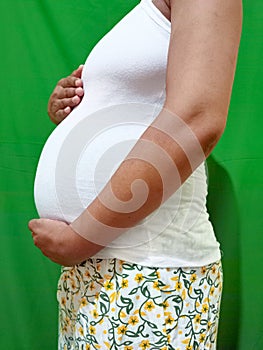 Pregnancy, 7 month of gestation, pregnant woman, big belly close-up, waiting for the birth of a child, pastel colors.