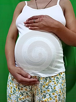 Pregnancy, 7 month of gestation, pregnant woman, big belly close-up, waiting for the birth of a child, pastel colors.