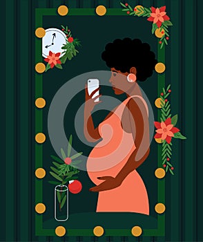 Pregnancy. An African woman takes a selfie in the mirror and holds smartphone in her hand