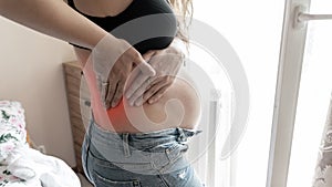 Pregnancy back pain. Beautiful pregnant woman suffer from back pain, backache. Ache spine therapy, healthcare concept.