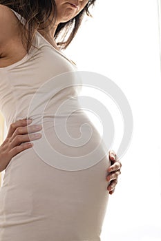 Pregnancy Backache. Pregnant Woman Having Lower Back Pain Standing Over white Background. Studio Shot