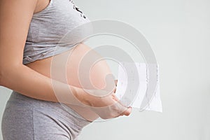 Pregnancy care. cardiotocography fetal heartbeat examination. pregnant woman holds in her hands the results Cardiotocography of