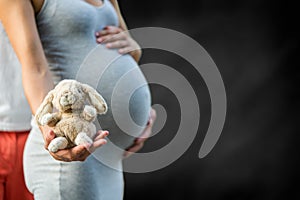 Pregnancy, couple holding a cuddle toy as a smybol for childhood