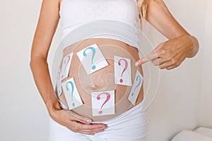 Pregnancy, determining the sex of the unborn child. question marks on the belly.boy or girl