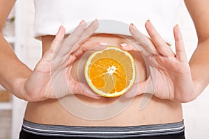 Pregnancy or diet concept, female hands holding orage. photo