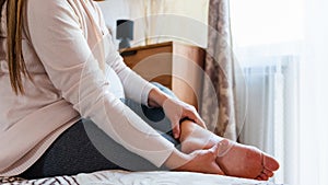 Pregnancy foot ankle pain. Pregnant woman have leg disease, ankle pain doing health massage exercise. Leg cramps during