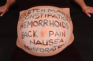 Pregnancy Health risks written on pregnant tummy