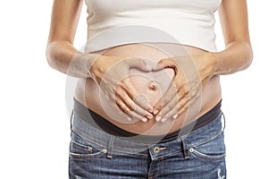 Pregnancy late term, close-up. Hands folded in the shape of a heart on a big belly. Isolated on a white background