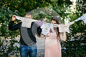 Pregnancy, married young couple with baby clothes