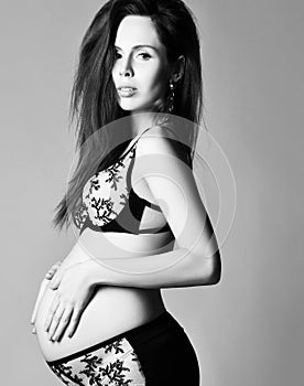 Pregnancy, maternity, preparation and expectation concept. Beautiful fashion pregnant woman holds hands on belly