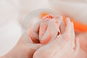 Pregnancy, maternity, preparation and expectation motherhood, giving birth concept. Newborn baby feet in hands of mommy