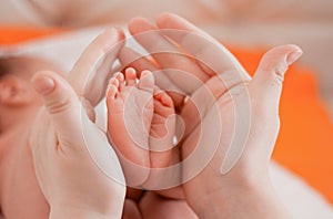 Pregnancy, maternity, preparation and expectation motherhood, giving birth concept. Newborn baby feet in hands of mommy