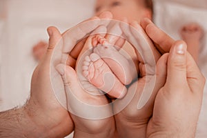 Pregnancy, maternity, preparation and expectation motherhood, giving birth concept. Newborn baby feet in hands of parents