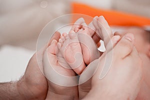 Pregnancy, maternity, preparation and expectation motherhood, giving birth concept. Newborn baby feet in hands of parents