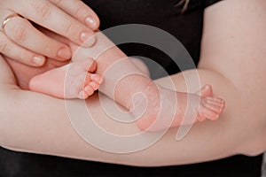 Pregnancy, maternity, preparation and expectation motherhood, giving birth concept. Newborn baby feet in hands of parents