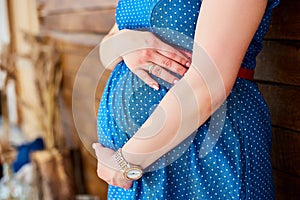 Pregnancy, motherhood and happy future mother concept. Pregnant woman holding her belly studio